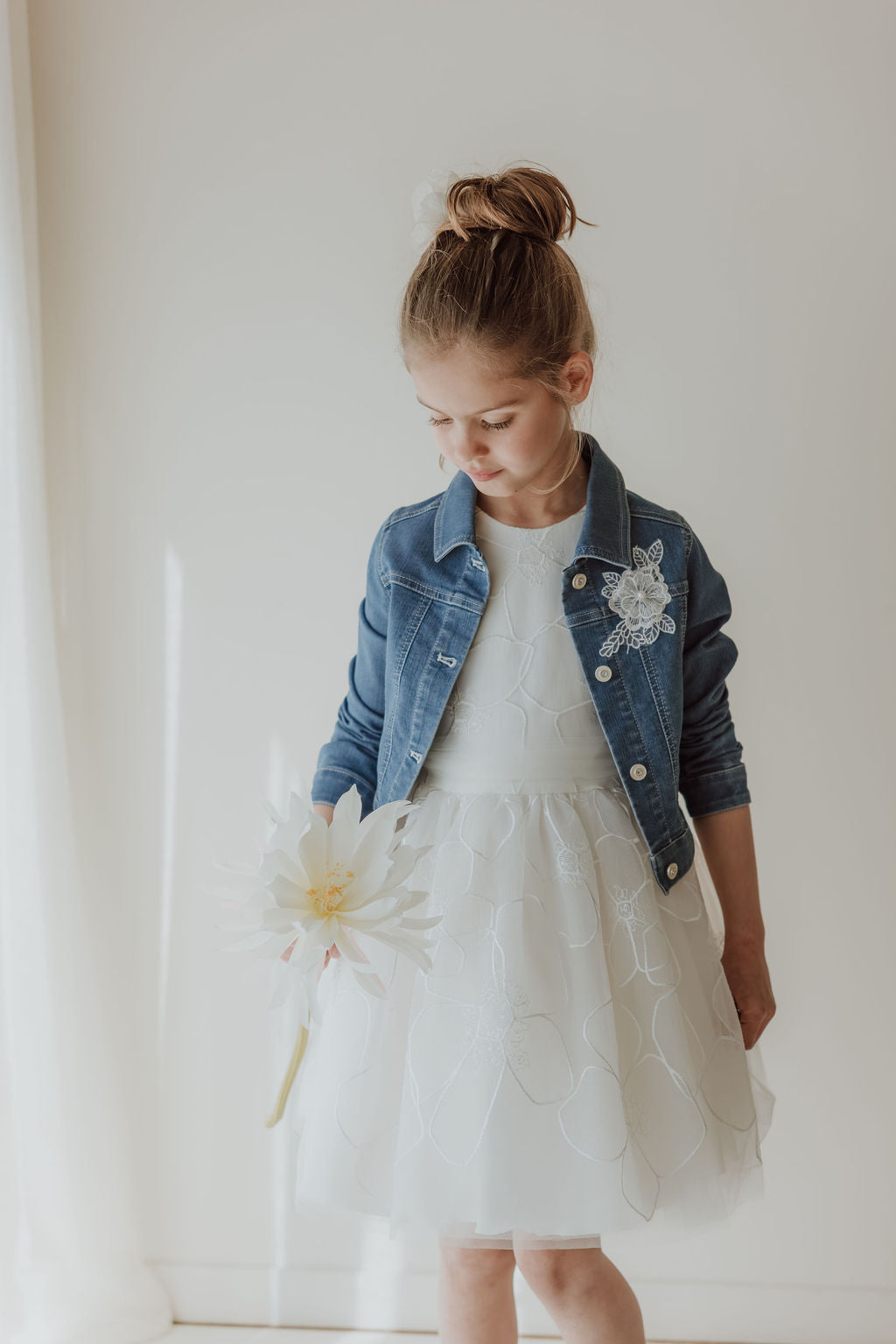 Witte communiejurk met denim jasje en bloemenborduursel