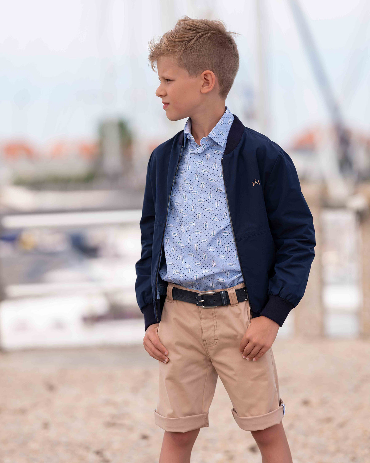 Coole Bomberjacke mit blau bedrucktem Hemd und beigen Bermudashorts