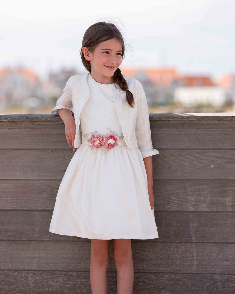 Weißes Kleid mit rosa Blumendetail und passender Strickjacke