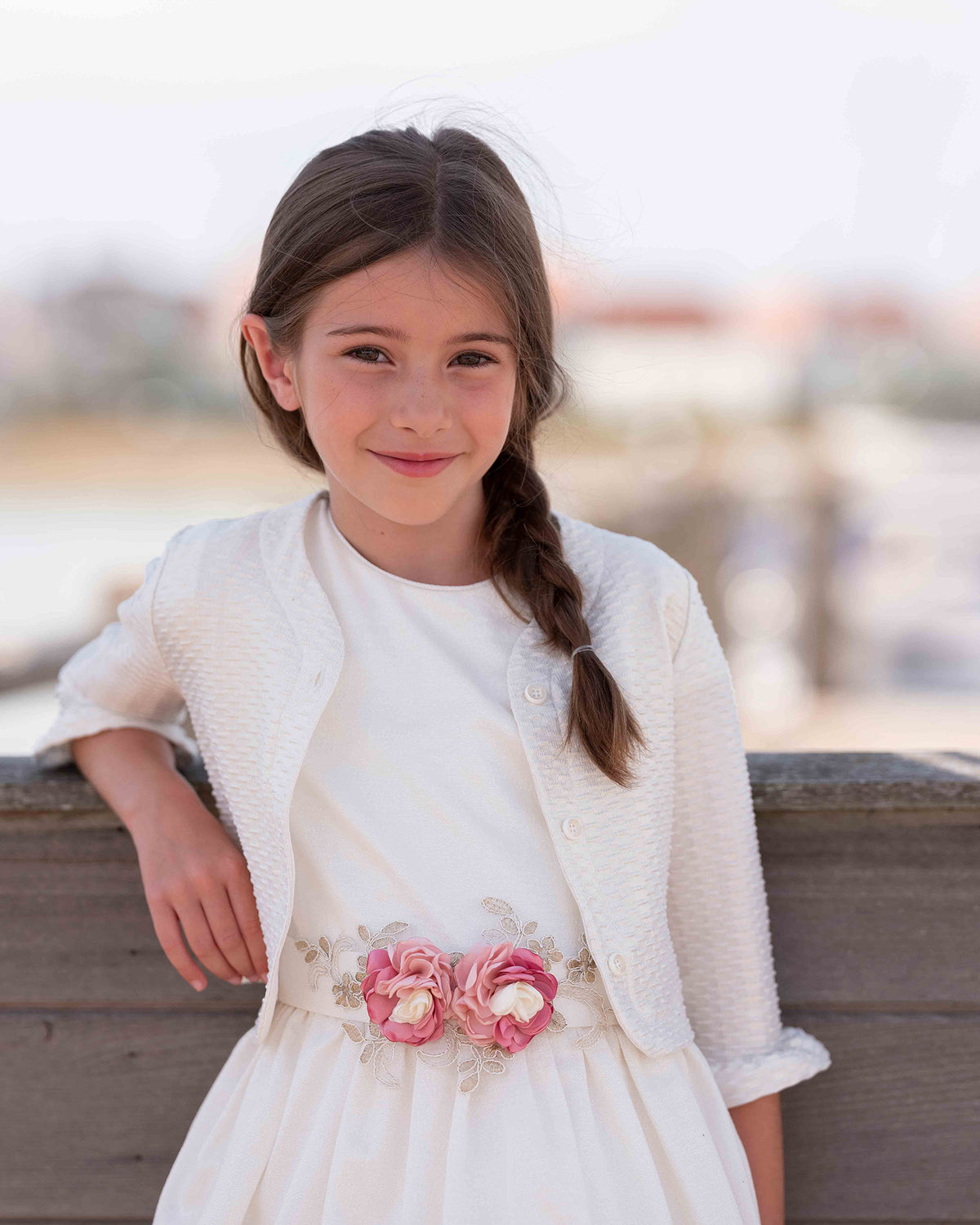 Weißes Kleid mit rosa Blumendetail und passender Strickjacke
